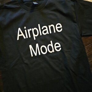 May include: Black t-shirt with white text that reads "Airplane Mode".