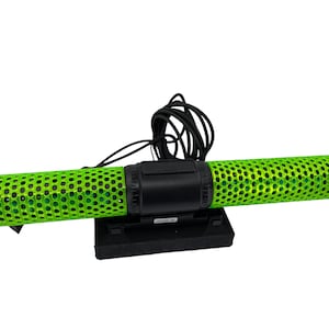 May include: A green and black submersible water pump with a black power cord. The pump has a green, perforated cylindrical body and a black base.