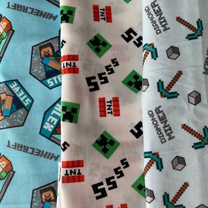 Puede incluir: Tres muestras de tela con dise&ntilde;os de Minecraft. La primera muestra es azul claro con un logotipo de Minecraft blanco y un patr&oacute;n repetido de picos y diamantes. La segunda muestra es blanca con un patr&oacute;n repetido de caras de Creeper verdes, 5 negros y bloques de TNT rojos. La tercera muestra es azul claro con un patr&oacute;n repetido de picos verdes y bloques grises.