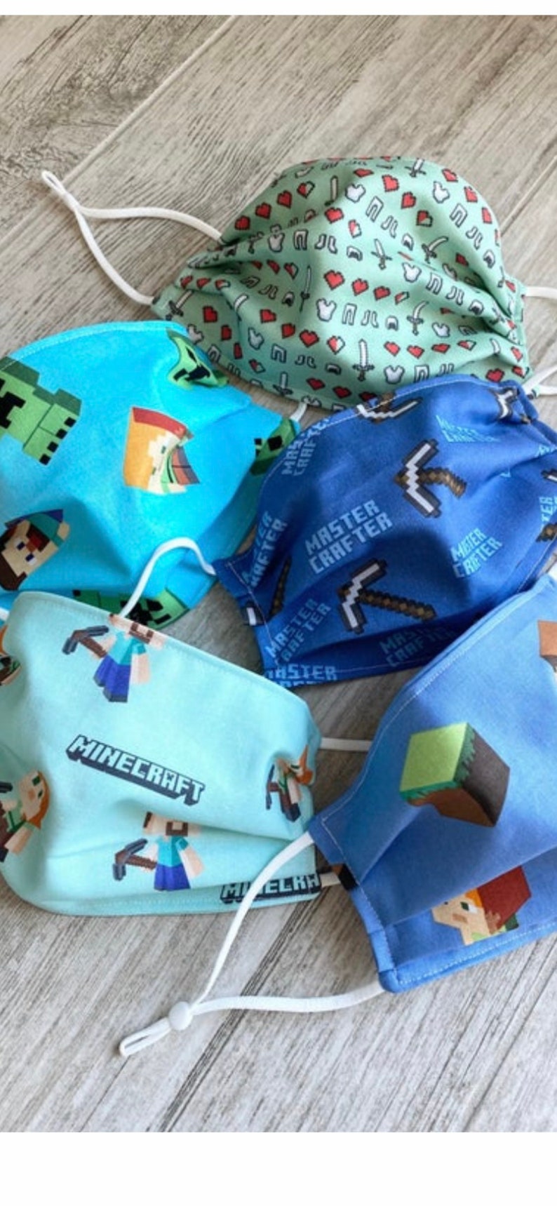 Puede incluir: Cuatro m&aacute;scaras faciales con tem&aacute;tica de Minecraft. Las m&aacute;scaras son azules, verdes, azul claro y verde claro. Las m&aacute;scaras tienen diferentes dise&ntilde;os, incluyendo un pico, un creeper y un personaje de Minecraft.