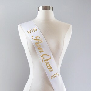 May include: White satin sash with gold glitter lettering that reads "WHS Prom Queen 2025".