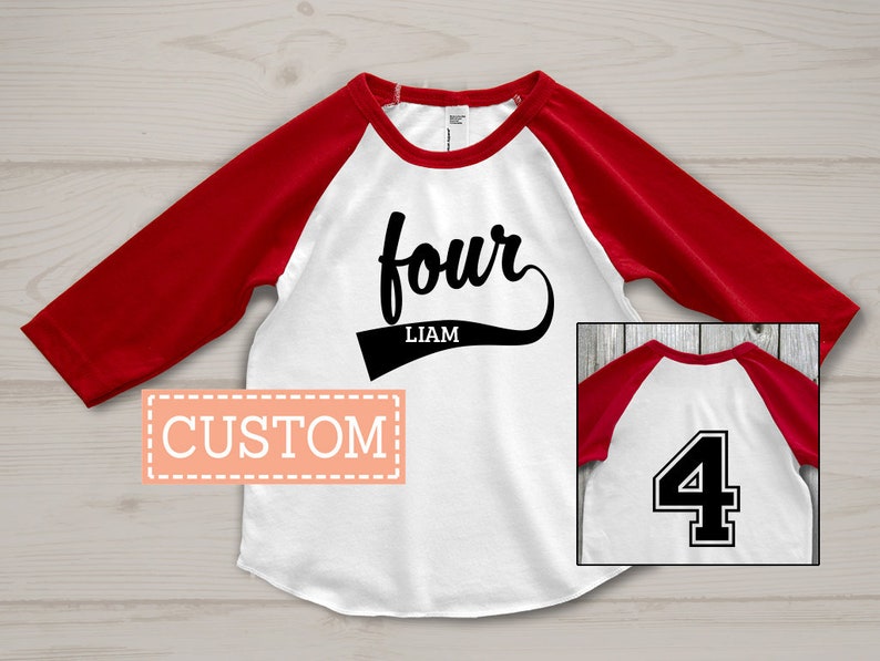 May include: A white and red baseball-style shirt with the word "four" in a script font and the name "Liam" below it. The shirt has red sleeves and a white body. A small image shows the number "4" on the back.