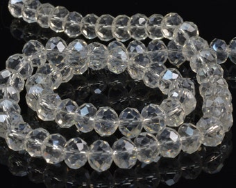 May include: A strand of clear faceted glass beads. The beads are round and have a slight iridescent sheen.