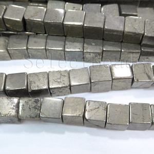 May include: A strand of pyrite beads, each bead is a cube with a metallic silver colour and a slightly rough texture.