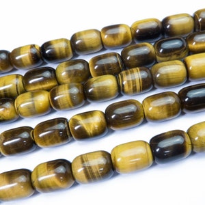 May include: A strand of tiger's eye beads, with a golden brown color and a subtle sheen. The beads are oval shaped and have a smooth, polished finish.