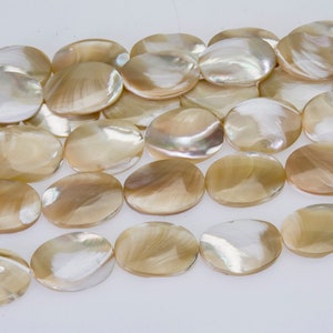 May include: A strand of oval-shaped, iridescent mother-of-pearl beads in a light brown colour.