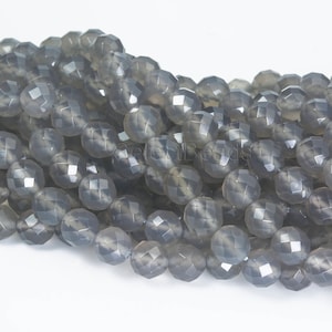 May include: A strand of grey faceted gemstone beads. The beads are round and have a smooth, polished finish.