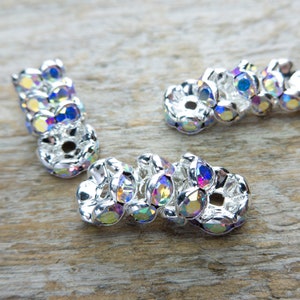 May include: Three silver-toned metal bead caps with iridescent rhinestones. The bead caps are designed to be used as end caps for jewelry making.