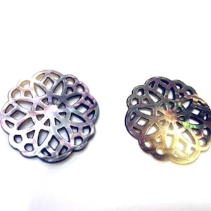 May include: Two iridescent mother of pearl decorative pieces with a circular, intricate, cut-out design.