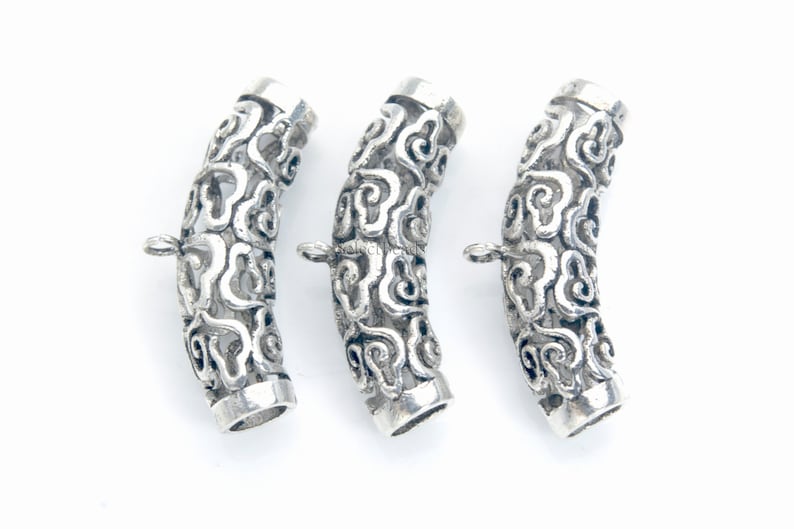 Pode incluir: Tr&ecirc;s pe&ccedil;as de conex&atilde;o de metal prateado para a fabrica&ccedil;&atilde;o de joias. Cada pe&ccedil;a &eacute; um tubo curvo com um design decorativo de nuvens em espiral.