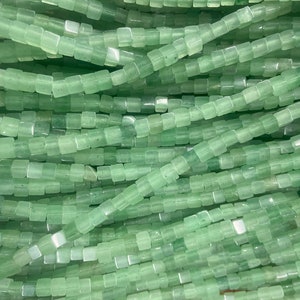 May include: A strand of light green square-shaped beads. The beads are made of natural stone and have a smooth, polished finish.