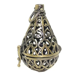 May include: A gold-toned metal incense burner with a heart-shaped design. The burner is open and has a delicate, intricate pattern.