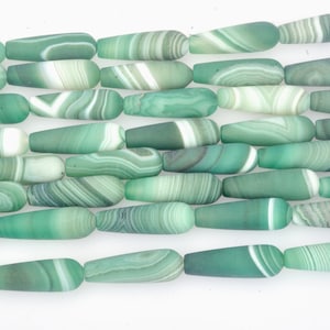 May include: A strand of green and white agate beads, each bead is a long, teardrop shape with a smooth, polished finish.