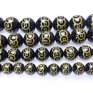 May include: Black beads with gold Chinese coin symbols. The beads are round and have a glossy finish.