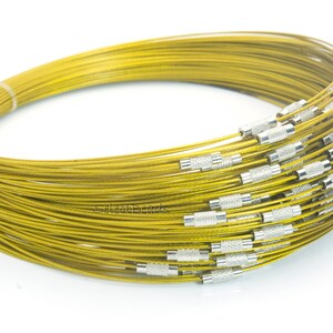 May include: A coil of gold-colored wire with silver-colored end caps. The wire is coiled in a circle and is about 10 inches in diameter.