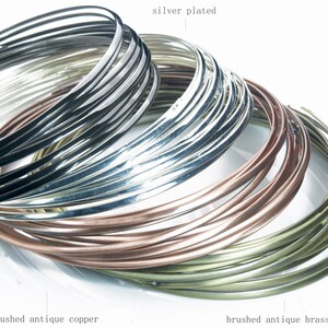 Puede incluir: Primer plano de una pila de alambre met&aacute;lico de diferentes colores. El alambre est&aacute; dispuesto en forma circular, con el alambre chapado en n&iacute;quel en la parte superior, seguido del alambre chapado en plata, el alambre de cobre antiguo cepillado y el alambre de lat&oacute;n antiguo cepillado.