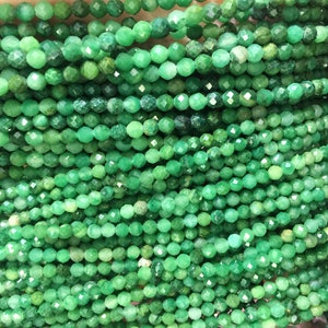 Peut inclure: Un brin de perles de pierres précieuses vertes, chaque perle est facetée et a une forme ronde.