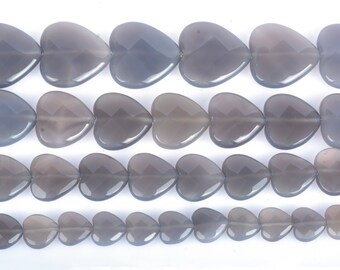 May include: A strand of gray heart-shaped gemstone beads. The beads are faceted and have a translucent appearance.