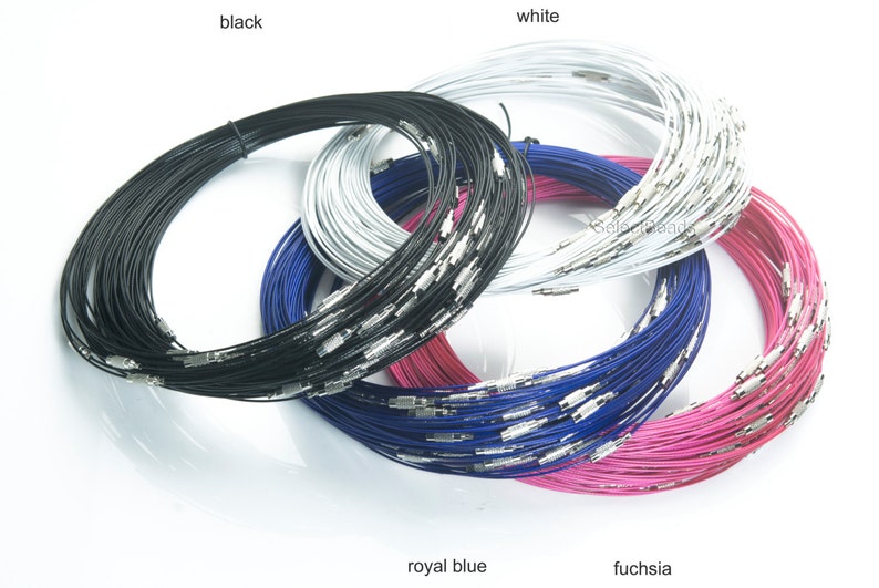 May include: A close-up of four spools of wire in different colors: black, white, royal blue, and fuchsia. The wire is thin and appears to be made of metal. The spools are stacked on top of each other.