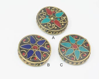 Könnte beinhalten: Drei runde, dekorative Metallperlen mit aufwendigen Designs. Jede Perle hat eine zentrale Blütenform mit türkisfarbenen, roten und blauen Emaille-Akzenten. Die Perlen sind von einem goldfarbenen Metallrahmen umgeben.