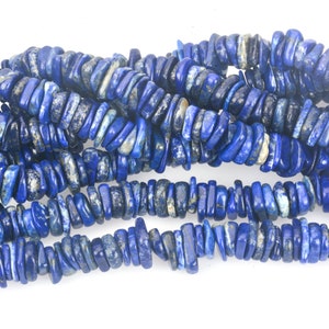May include: A strand of blue lapis lazuli gemstone beads. The beads are irregular in shape and have a chipped, rough texture.