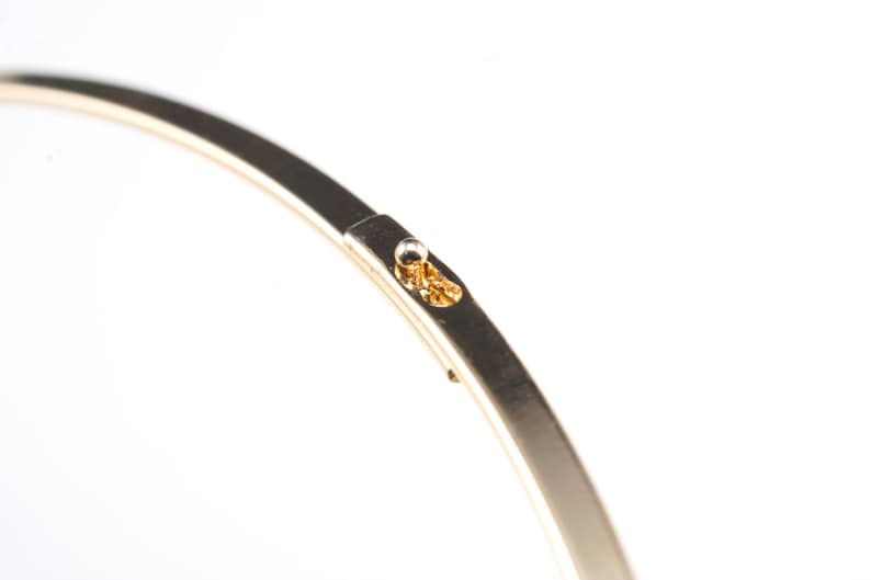 Puede incluir: Un brazalete de metal dorado con un peque&ntilde;o cierre redondo.