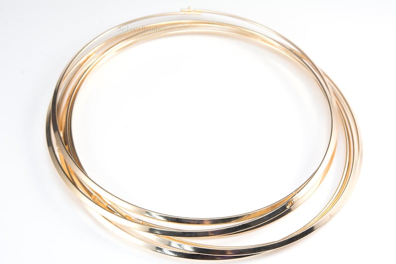 Puede incluir: Tres aros de metal de color dorado, apilados uno encima del otro, formando un c&iacute;rculo.