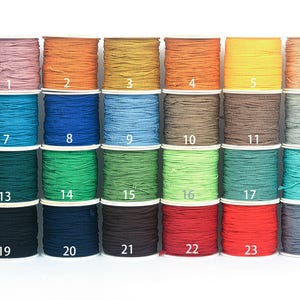May include: A collection of 24 spools of colorful cord in various shades, including pink, orange, yellow, and blue. Each spool is labeled with a number from 1 to 24, offering a wide range of colors for crafting projects.