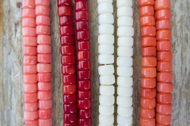 Puede incluir: Seis hebras de cuentas en varios tonos de rosa, rojo y blanco. Las cuentas son todas de forma cuadrada y tienen un acabado brillante.