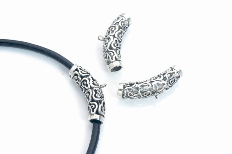 Pode incluir: Tr&ecirc;s pontas de cord&atilde;o de metal prateadas com um padr&atilde;o decorativo de nuvens. As pontas de cord&atilde;o s&atilde;o projetadas para serem usadas com cord&atilde;o de couro.