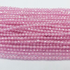 May include: A strand of pink crystal beads. The beads are round and have a faceted finish. The beads are strung on a clear thread.