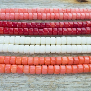 Puede incluir: Cuatro hebras de cuentas de coral en diferentes tonos de rosa, rojo y blanco. Las cuentas son redondas y tienen un acabado liso y pulido.