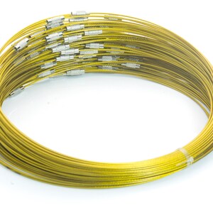 May include: A bundle of gold-colored metal wire, coiled into a circle. The wire is thin and flexible, and it is likely used for jewelry making or other crafts.