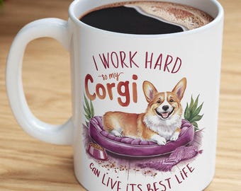 Może przedstawiać: Biały ceramiczny kubek do kawy z kreskówkową ilustracją psa rasy corgi leżącego w fioletowym legowisku. Tekst na kubku brzmi: "Ciężko pracuję, żeby mój corgi mógł żyć najlepszym życiem."