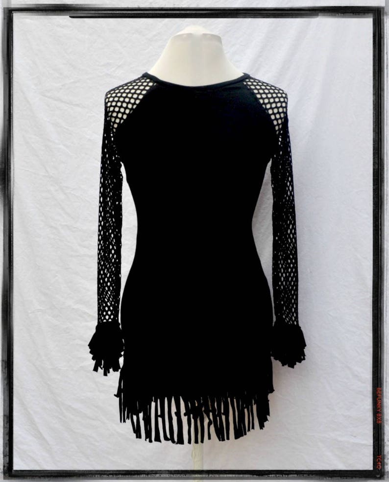May include: Black long-sleeved dress with a mesh panel on the shoulders and a fringe hem.