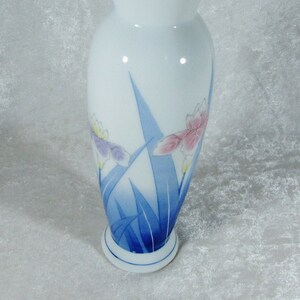 May include: A white porcelain vase with a blue and white floral design. The vase has a rounded body and a flared top.