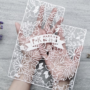May include: White paper cut-out of the state of Utah with a floral design. A banner across the middle reads "P*K Married 06-23-18".