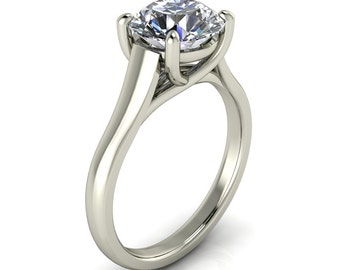 May include: A silver engagement ring with a large, round, clear diamond set in a prong setting. The band is thick and has a delicate design.