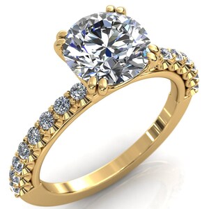 May include: A gold engagement ring with a large round diamond center stone and smaller diamonds set in a pave band.