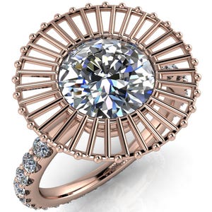 Puede incluir: Un anillo de oro rosa con un gran diamante redondo engastado en un delicado diseño de rayos de sol. La banda del anillo también está engastada con diamantes más pequeños.