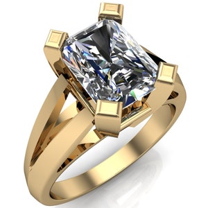 May include: A gold ring featuring a large, clear, rectangular-shaped diamond. The diamond is set in a gold setting with four prongs.