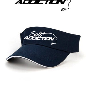 May include: A navy blue visor with a white embroidered logo that says "Salt Addiction" with a fishing hook and line design.