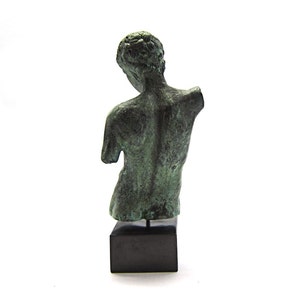 Pu&ograve; includere: Una scultura in bronzo di una figura nuda, in piedi su una base nera. La scultura &egrave; verde e ha una finitura anticata.