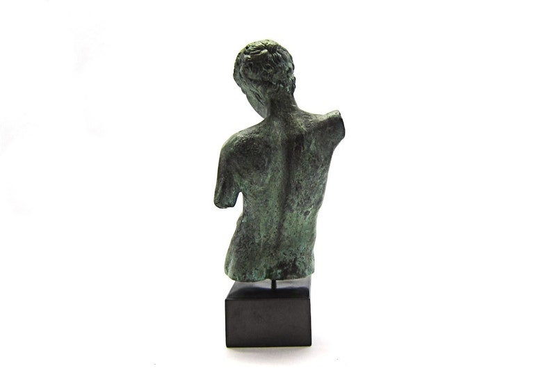 Pu&ograve; includere: Una scultura in bronzo di una figura nuda, in piedi su una base nera. La scultura &egrave; verde e ha una finitura anticata.