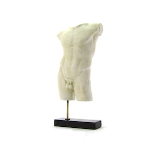 Può includere: Scultura in gesso bianco di un torso maschile su un piedistallo nero.
