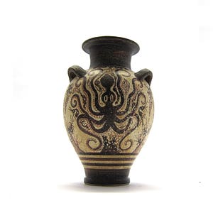 May include: A small, brown and white ceramic vase with a design of an octopus with tentacles. The vase has a round body and a narrow neck.