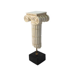 May include: White plaster column capital with a decorative scroll design on the top, mounted on a black square base.
