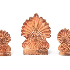 Può includere: Tre sculture in ceramica a forma di conchiglie stilizzate con dettagli intricati. Le sculture sono di colore marrone chiaro e hanno una superficie testurizzata.