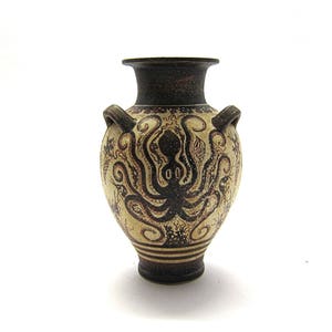 May include: A small, white ceramic amphora with brown painted details. The amphora features a stylised octopus design.