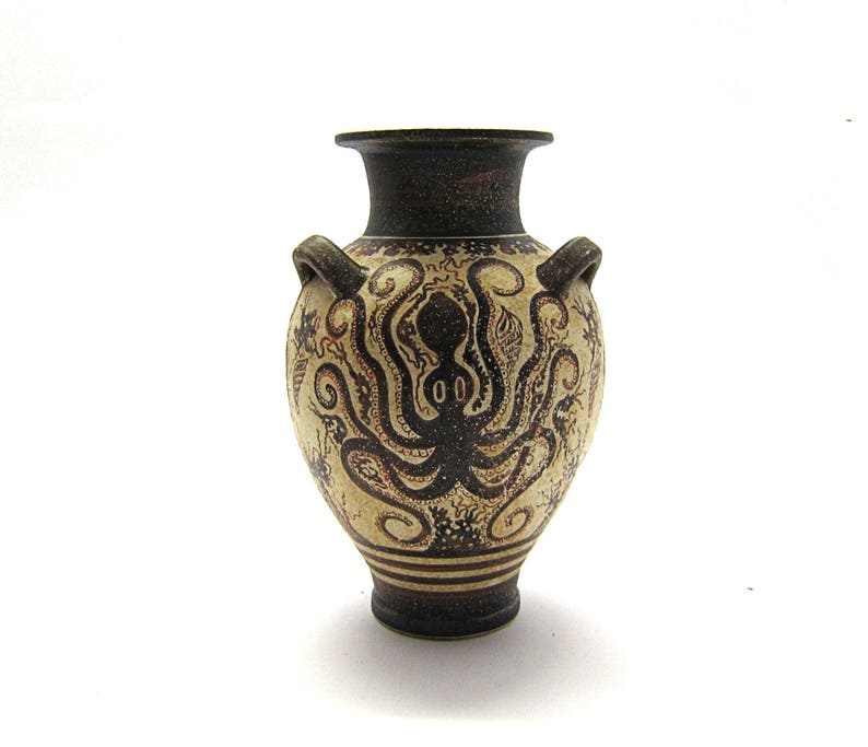 May include: A small, white ceramic amphora with brown painted details. The amphora features a stylised octopus design.